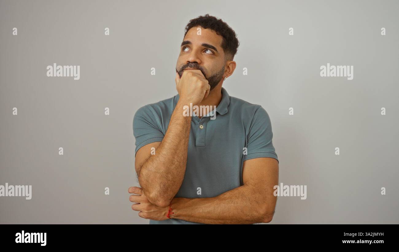Junger hispanischer Mann, der über einen isolierten weißen Hintergrund nachdenkt. Stockfoto