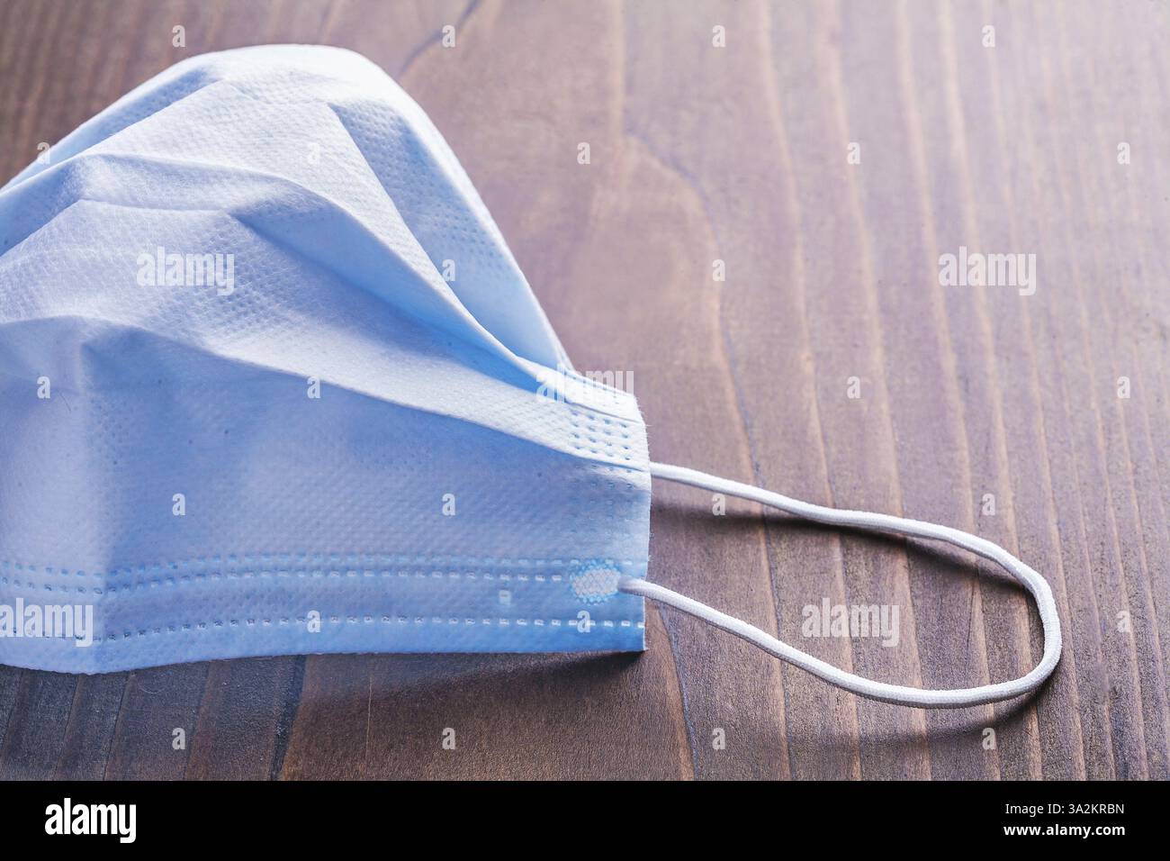 Chirurgische Maske auf Vintage-Holzbrett-medizinischem Konzept Stockfoto