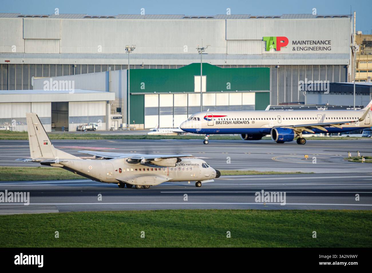 Lissabon, Portugal - 3. April 2024: Die portugiesischen Luftwaffe Airbus C295 und British Airways Airbus A321neo fahren auf dem Flughafen Lissabon. TIPPEN SIE AUF Maintenance and Engineering Hangar und Infrastruktur, geschäftiger internationaler Hub Stockfoto