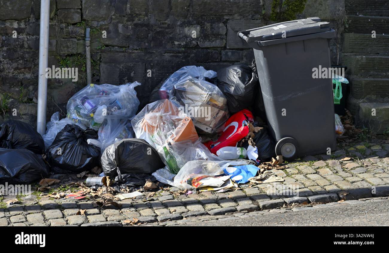 Tüten mit Fliegenstreu neben dem Mülltonnen auf dem Bürgersteig, Großbritannien Stockfoto