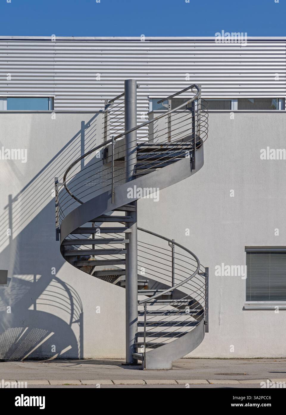Metallspiraltreppen ins Nirgendwo beim Außenbereich des Industriebaus Stockfoto