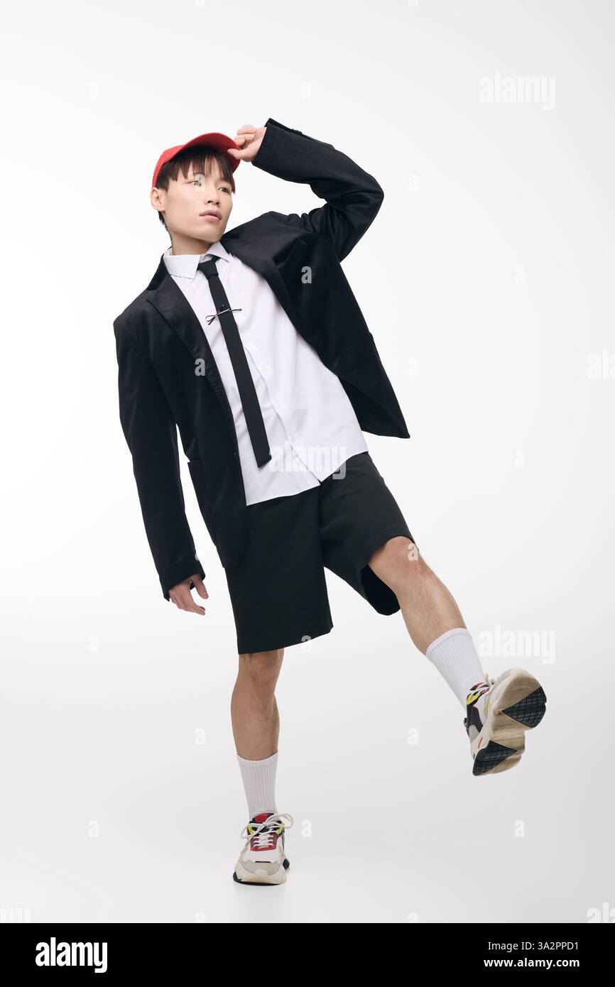 Ein stilvoller junger asiatischer Mann posiert selbstbewusst und verbindet Mode und Charisma. Stockfoto