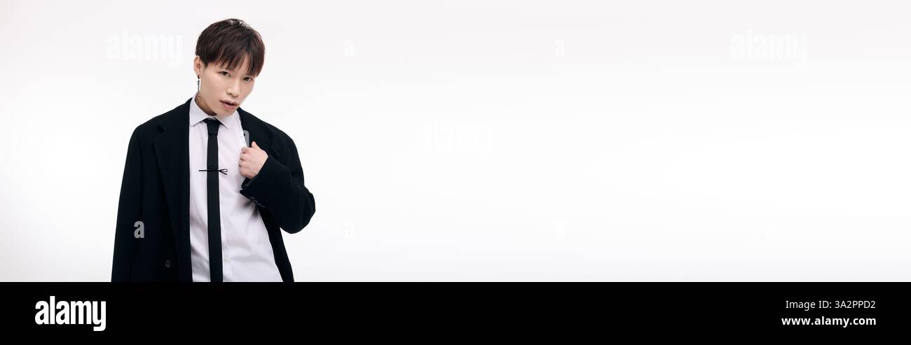 Ein fesselnder junger Mann zieht mit einem formellen Outfit und selbstbewusster Atmosphäre die Aufmerksamkeit auf sich. Stockfoto