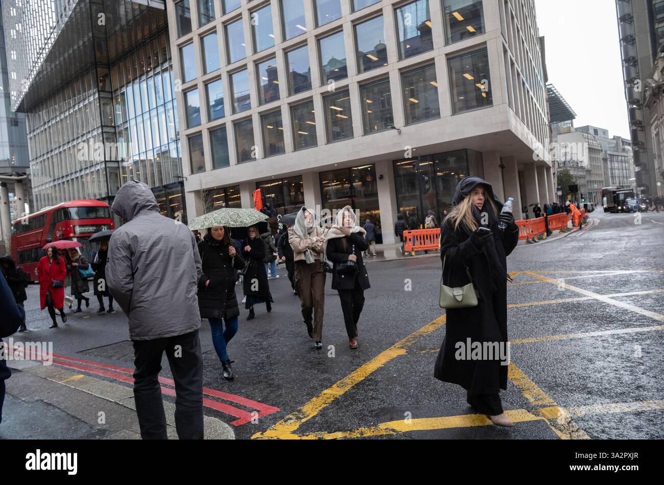 Stadtarbeiter überqueren das Bischopsgate bei einem Regenschauer, City of London, England, Vereinigtes Königreich Stockfoto