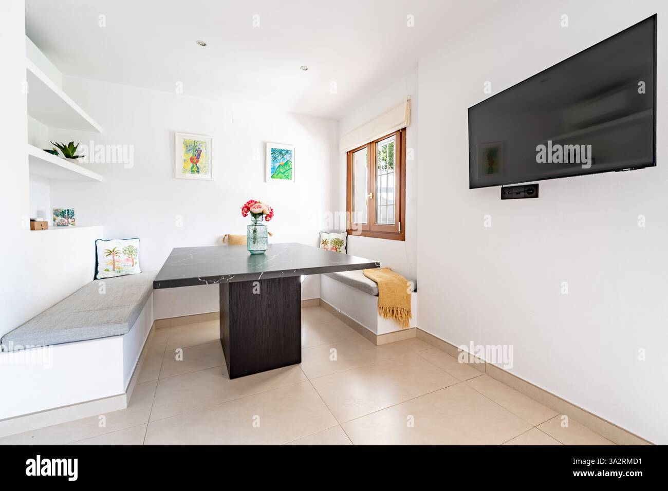 Ein Bild eines kleinen Essbereichs mit wandmontiertem Fernseher in der Ferienwohnung Stockfoto