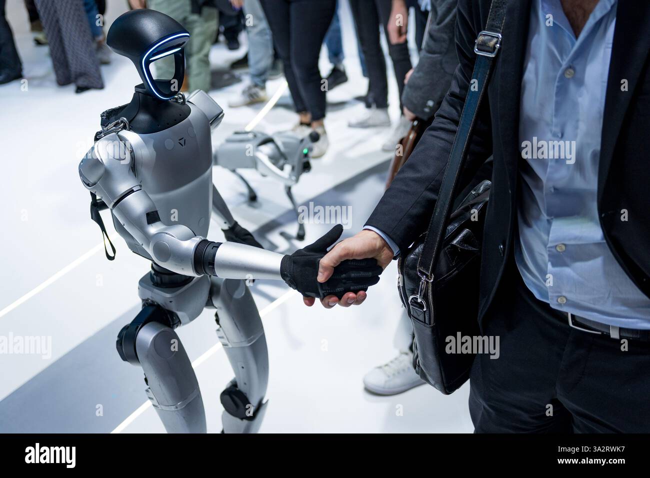 Ein humanoider Roboter der Firma Unitree wird gesehen, wie er Menschen in einem Handschlag die Hand schüttelt. Konzept der Mensch- und Roboterinteraktion und Robotertechnik Stockfoto