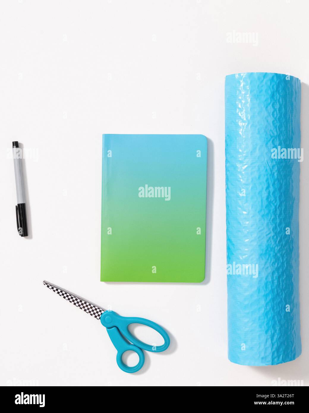 Buchmockup-Vorlage auf weißem Hintergrund mit Schere, Marker, Verpackungsfolie und Kopierraum Stockfoto