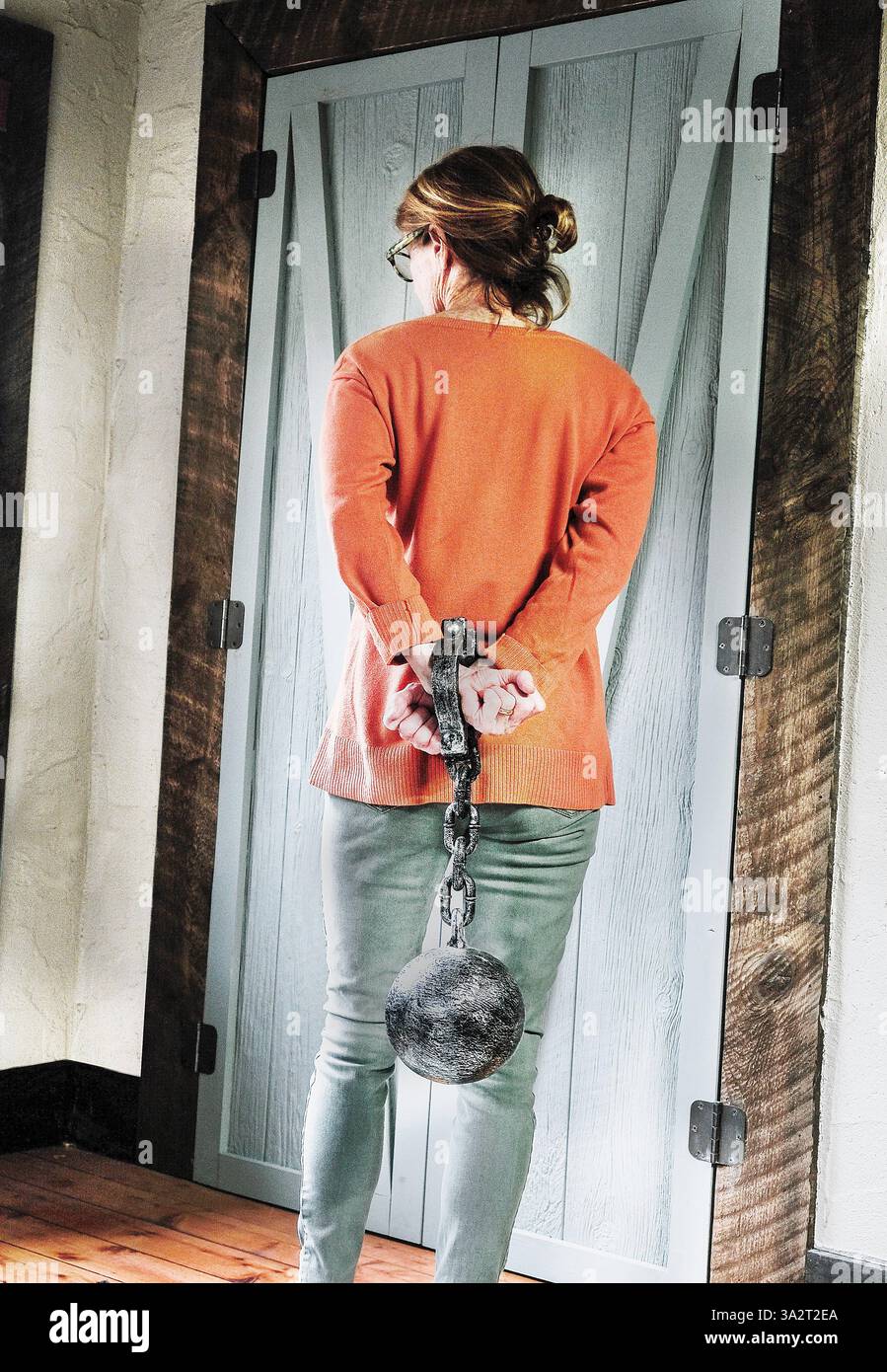 Frau weg Suchen mit Kugel und Kette an die Hände gebunden Stockfoto