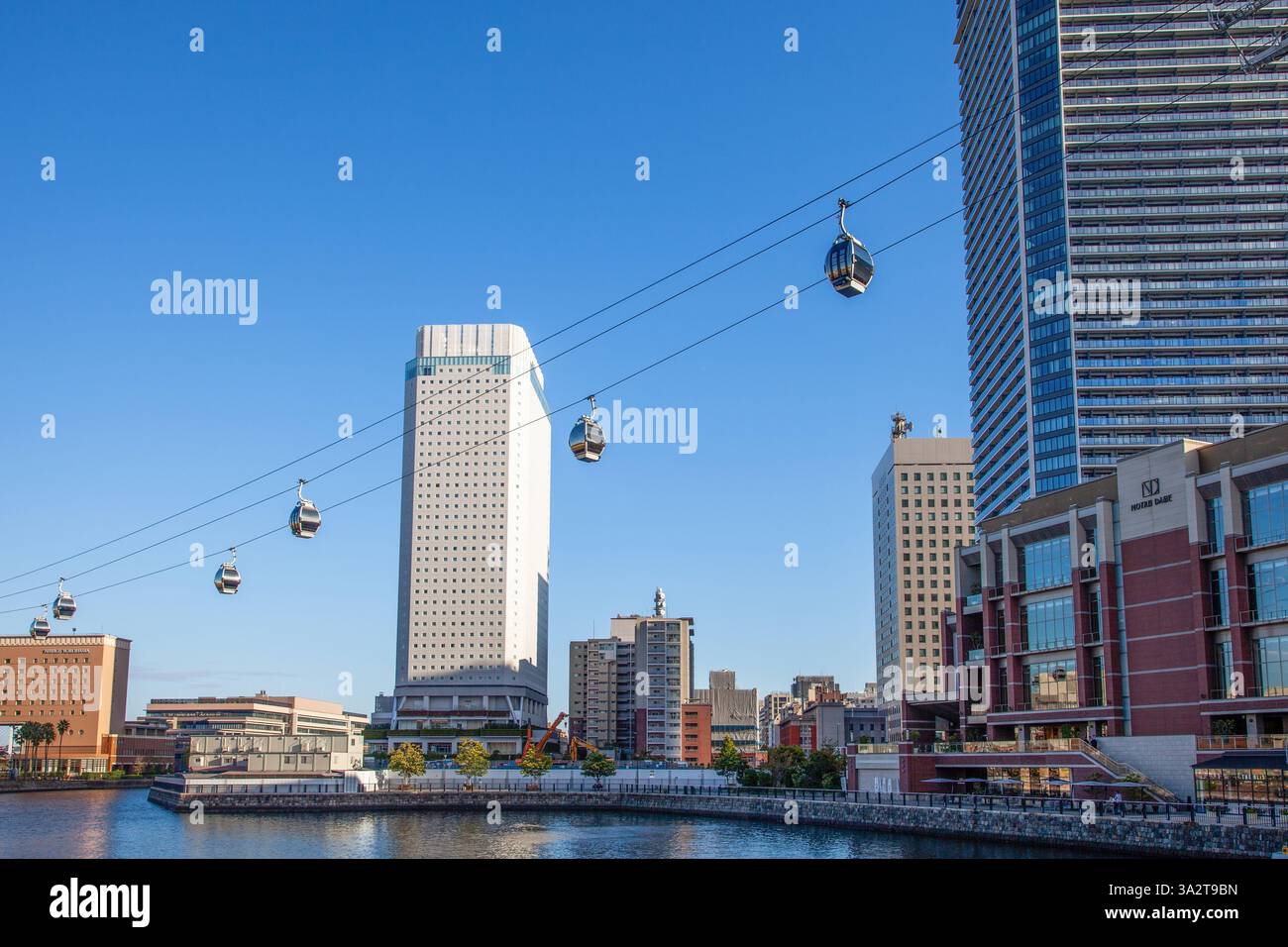 Die Yokohama Air Cabin Cable Car System mit dem APA Hotel and Resort Yokohama Bay Tower in Yokohama, Japan. Stockfoto