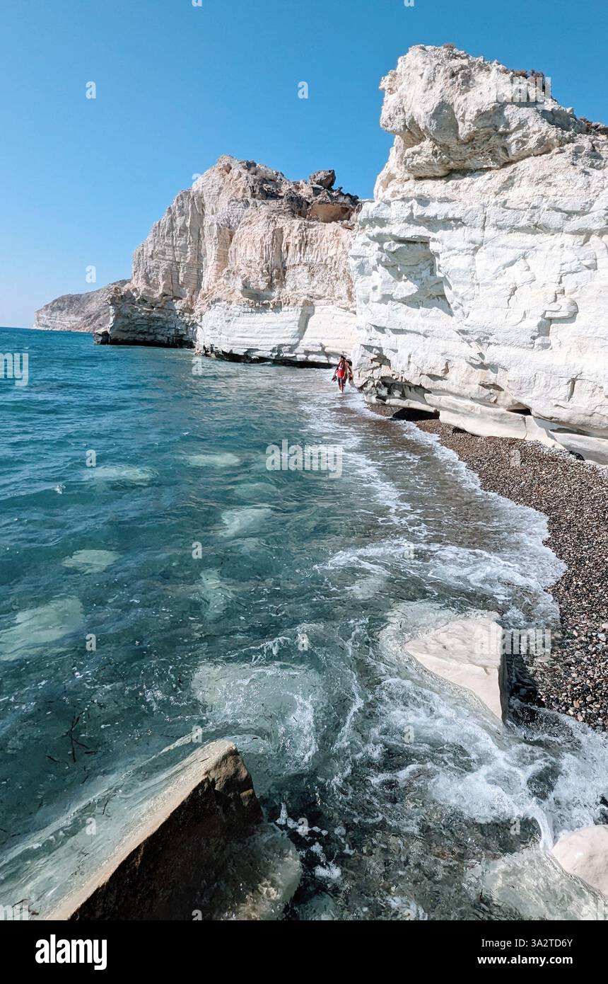 Eine Einzelfigur spaziert entlang der markanten weißen Klippen des Kap Aspro, wo Land auf das türkisfarbene Meer in Limassol, Zypern, trifft. Stockfoto