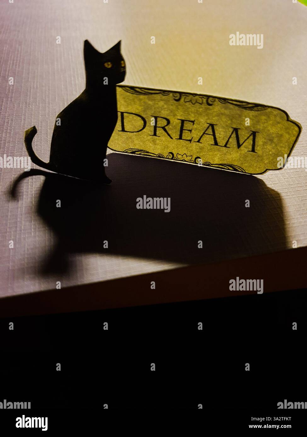 Konzeptuelle Collagekunst einer schwarzen Katze neben dem Text „Dream“ Stockfoto