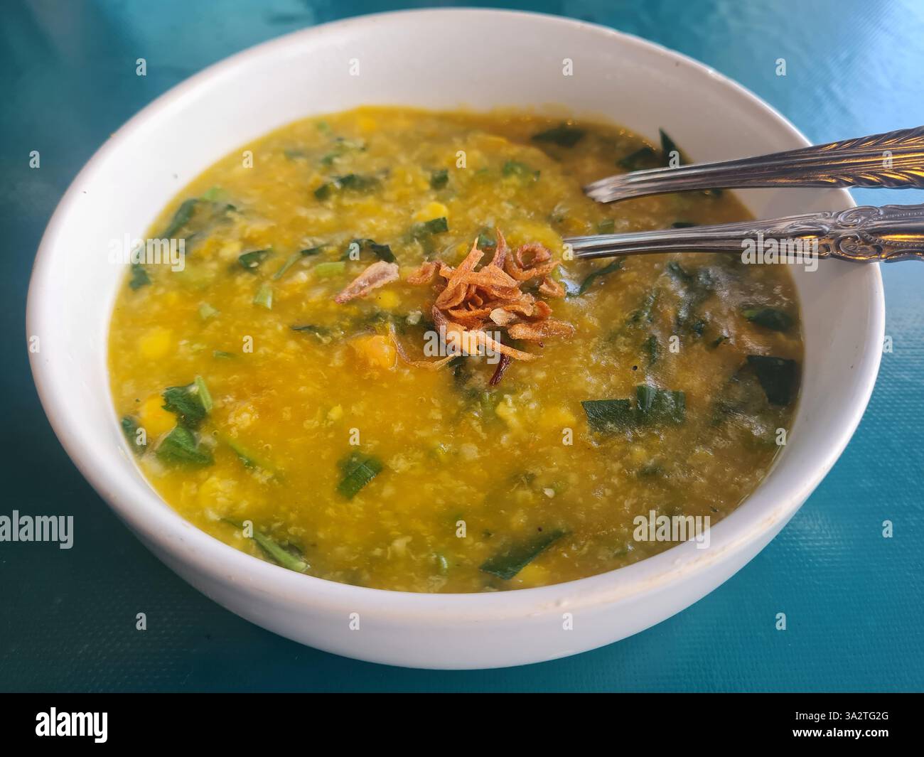 Bubur manado oder Tinutuan Brei, traditioneller Brei. Manadonesischer Reisbrei, gemischt mit Kürbis, Mais, Gemüse. Serviert mit gesalzenem Tofu-Fisch. Stockfoto