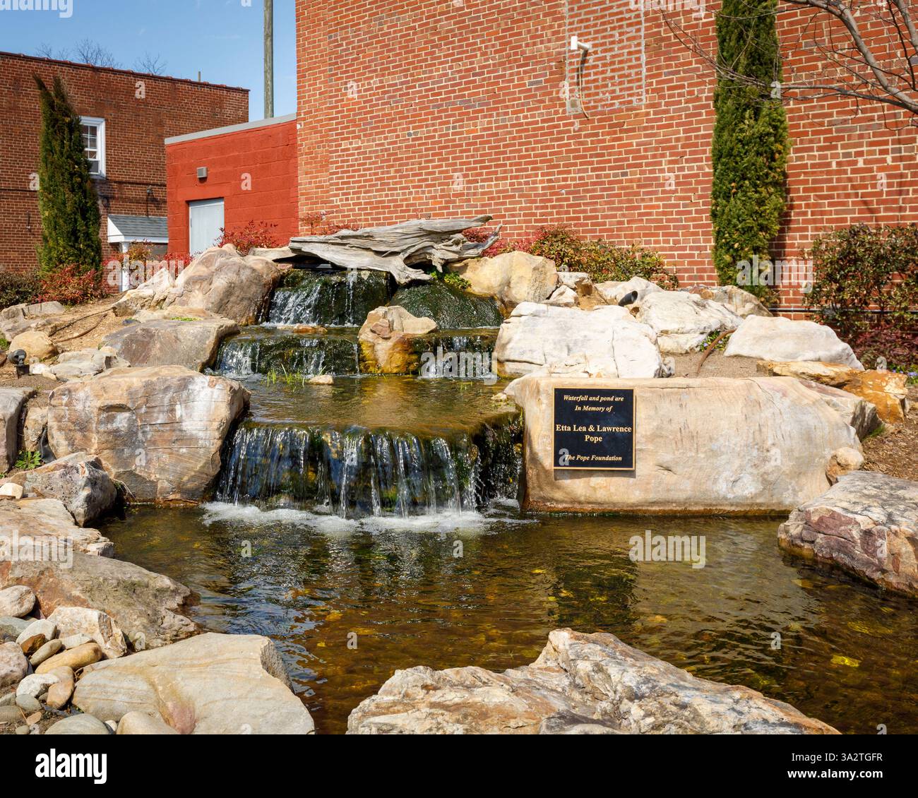 Kernersville, North Carolina, USA-8. März 2025: Founders' Park. Nahaufnahme des Wasserfalls und des Widmungsschilds. 4 x 5 Seitenverhältnis. Stockfoto