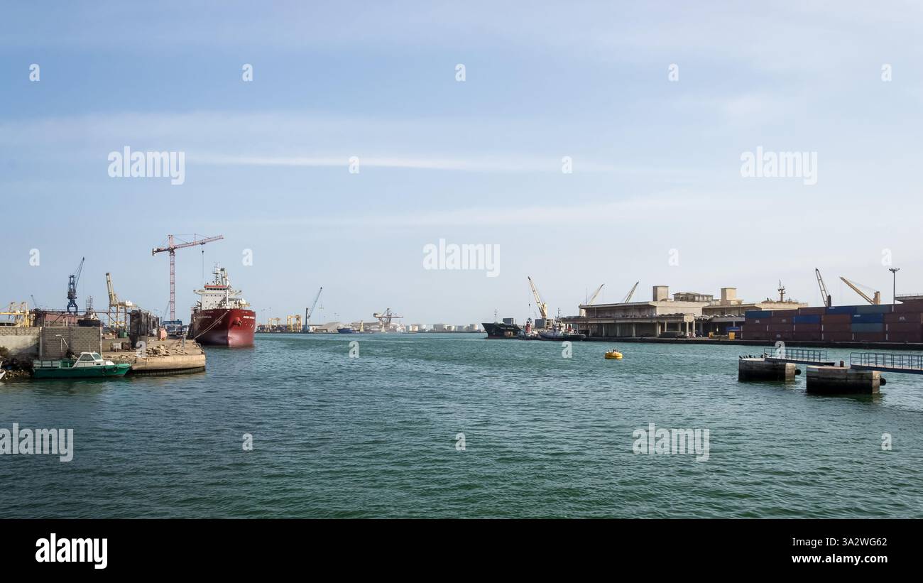 Dakar, Senegal – Blick auf den Hafen von Dakar, einen belebten westafrikanischen Hafen. Frachtkräne und Frachtcontainer heben den Seehandel hervor. Stockfoto