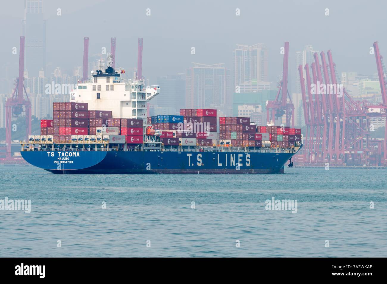 Hongkong. China- 02.18.2025. Ein Container-Massengutfrachter mit Frachtcontainern, der in den Hafen von Hongkong einfährt. Stockfoto