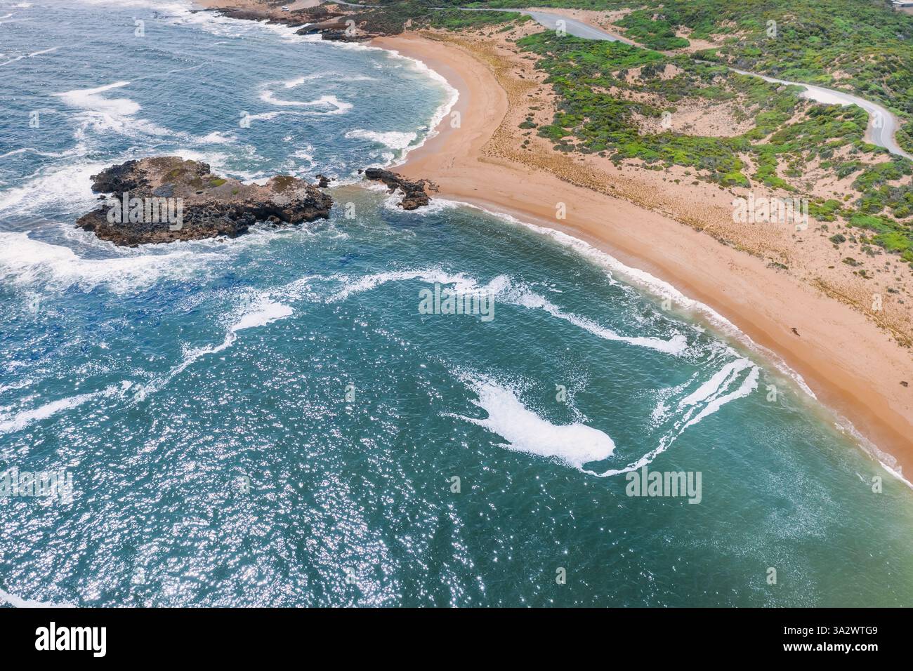 Aus der Vogelperspektive des geschwungenen Sandstrangs führt zu einem Felsvorsprung bei Beachport an der Kalksteinküste in South Australia. Stockfoto