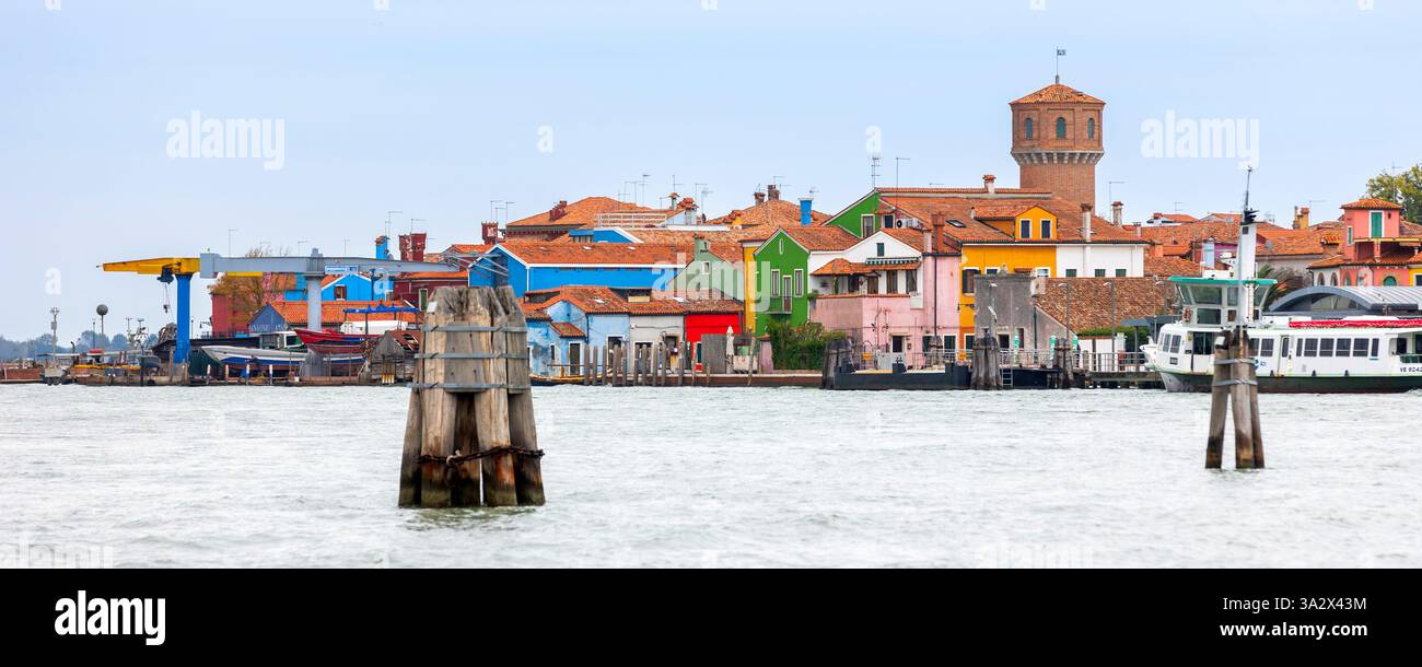 Insel Burano, Italien - 1. Oktober 2024: Bunte Häuserarchitektur, Blick vom Meer, Straße auf der berühmten Insel in der Nähe von Venedig. Reise- und Urlaubskonz Stockfoto