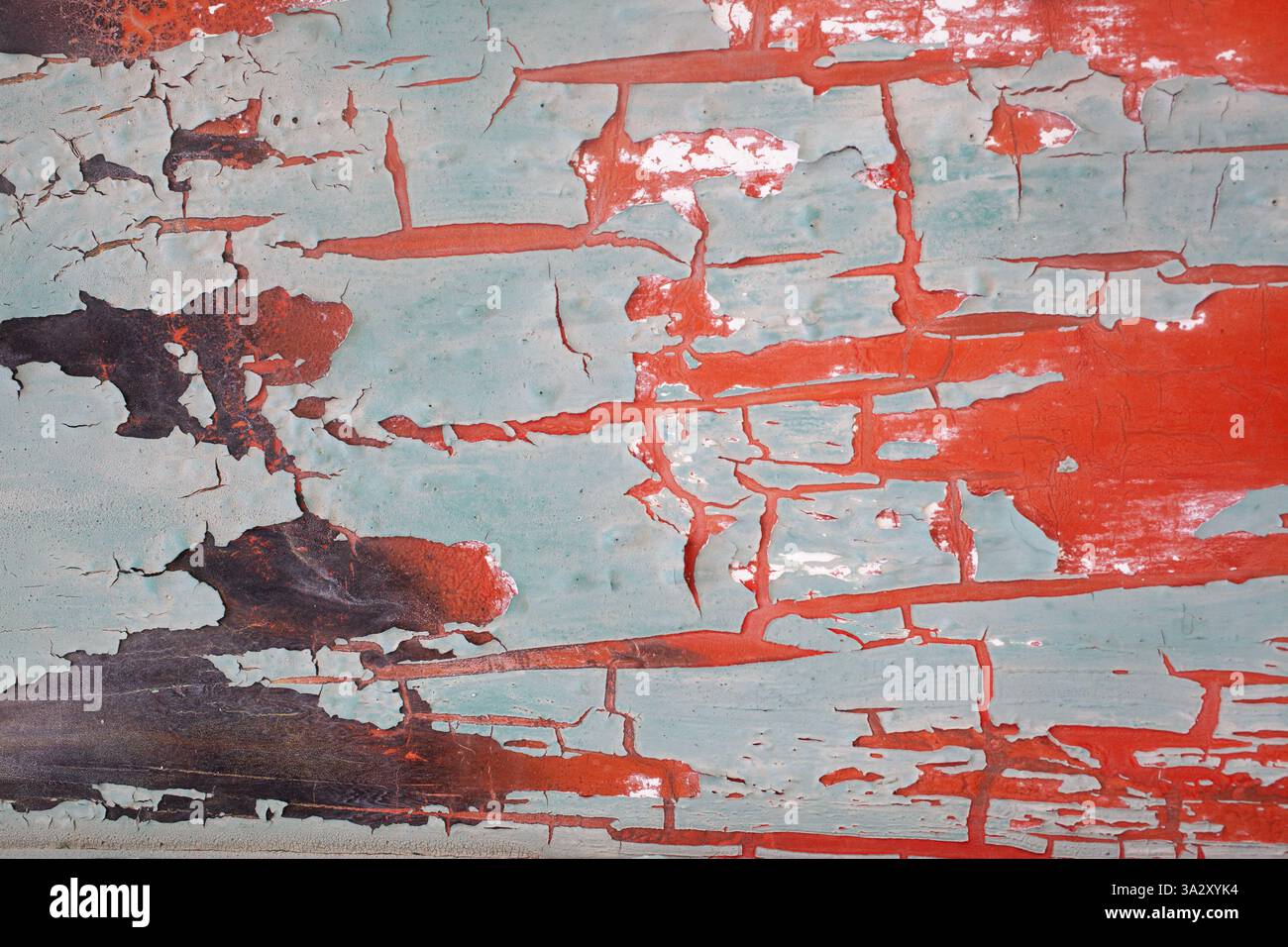 Blasser Lack blättert von roter Unterseite ab Stockfoto