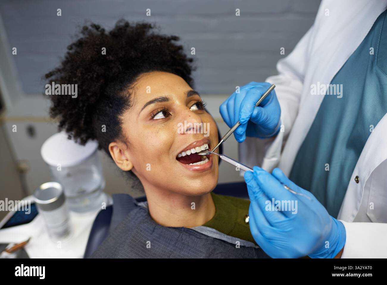 Lächelnde Patientin während einer Zahnarztuntersuchung in einer modernen Klinik Stockfoto