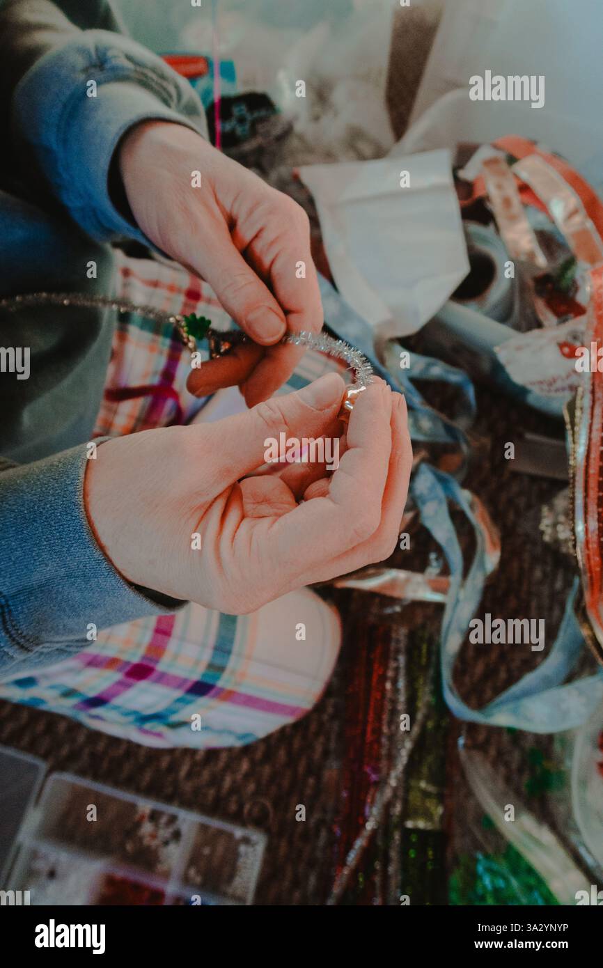 Eine Frau, die ein Urlaubshandwerk mit Perlen macht Stockfoto