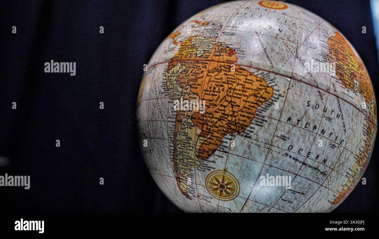 Table World Globe Modell in blau und braun isoliert auf schwarzem Hintergrund. Stockfoto