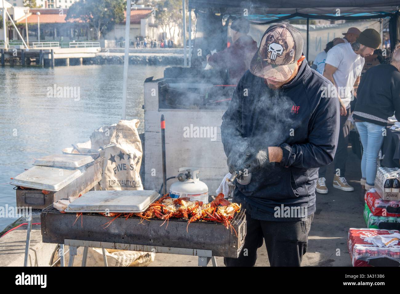Man grillt Hummer am Thuna Harbor Dockside Market in San Diego, Kalifornien, Charring the Hummer with A Blow Fackel, 15. Februar 2025 Stock Photo Stockfoto