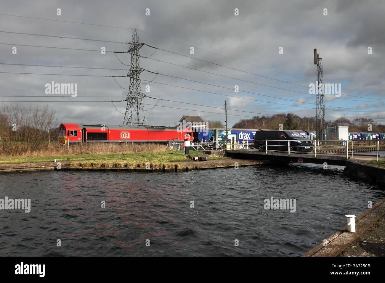 Die DB Cargo Class 66 passiert am 25.02.25 die Bahnüberquerung von Medge Hall mit dem Biomassezug 1013 6H63 Immingham nach Drax Power Station. Stockfoto