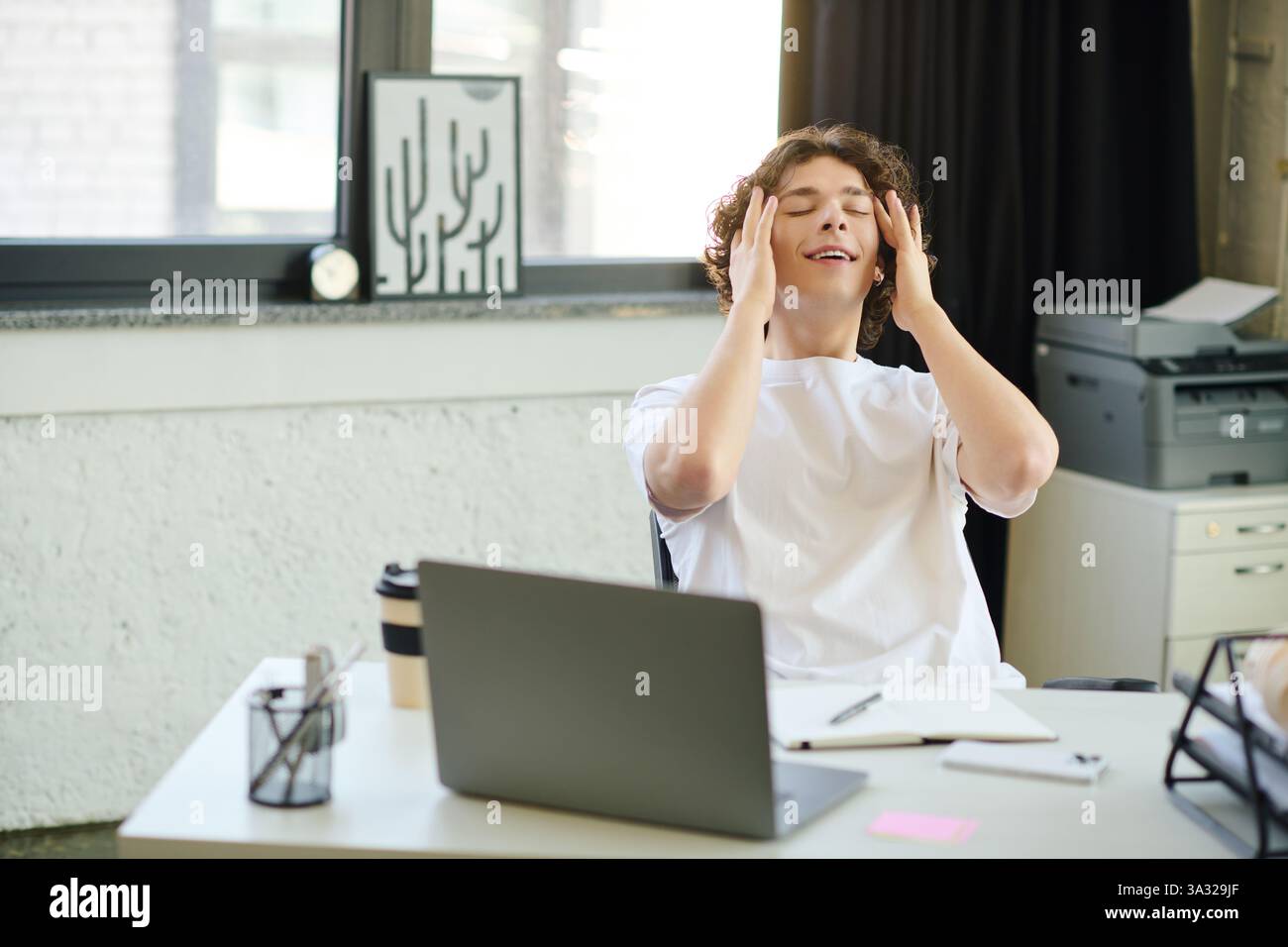 Junge Profis fühlen sich an einem hektischen Arbeitstag in einem hellen und stilvollen Arbeitsplatz überwältigt. Stockfoto