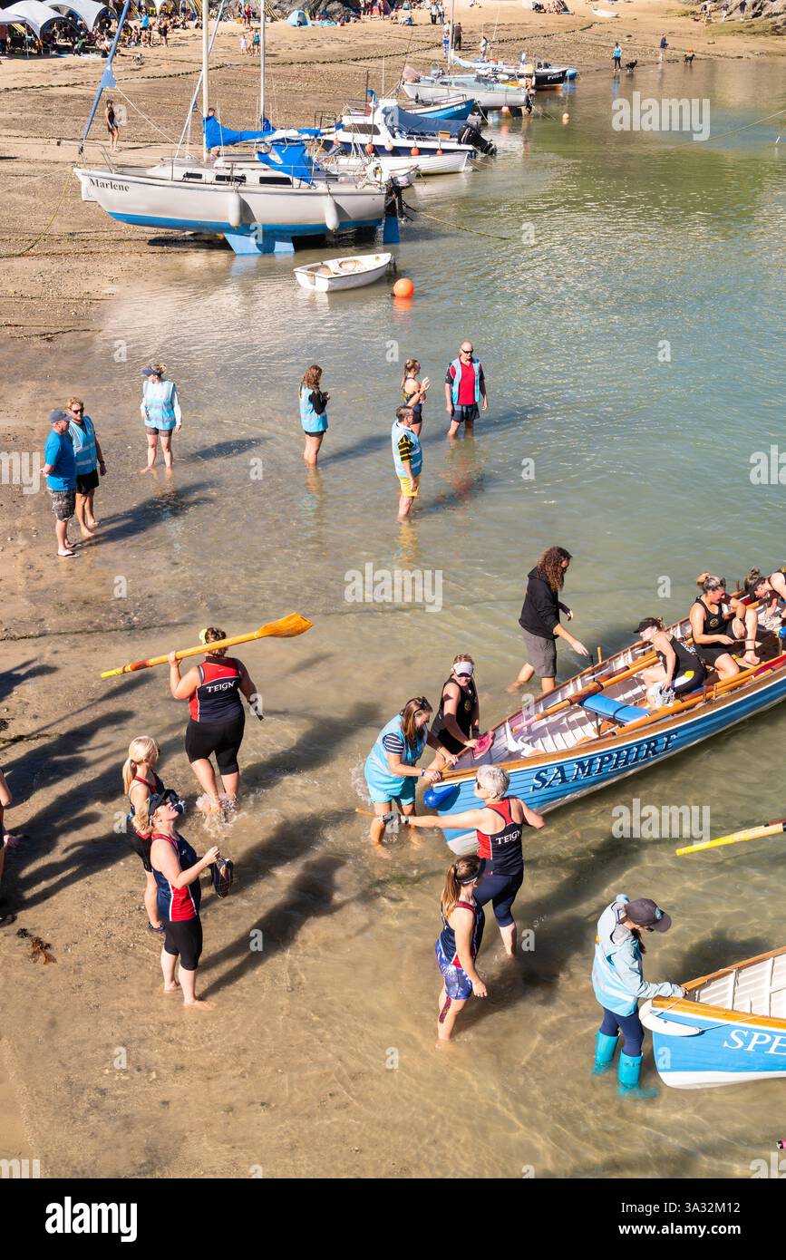 Piloten-Gig-Crews mit Rudern warten darauf, an Bord ihrer Piloten-Gigs für die Women's Newquay County Championships Cornish Pilot Gig Rowing in Newqu zu gehen Stockfoto