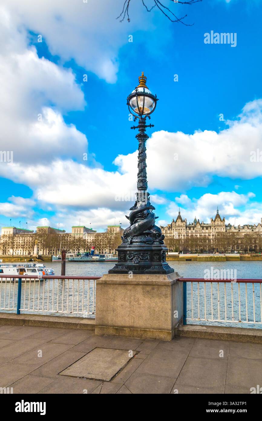 Toller Blick auf eine Dolphin-Lampe auf Queen's Walk, London. Zwei stilisierte Delfine oder Störe schlängeln sich um die Basis eines Standard-Lampenpfosten,... Stockfoto