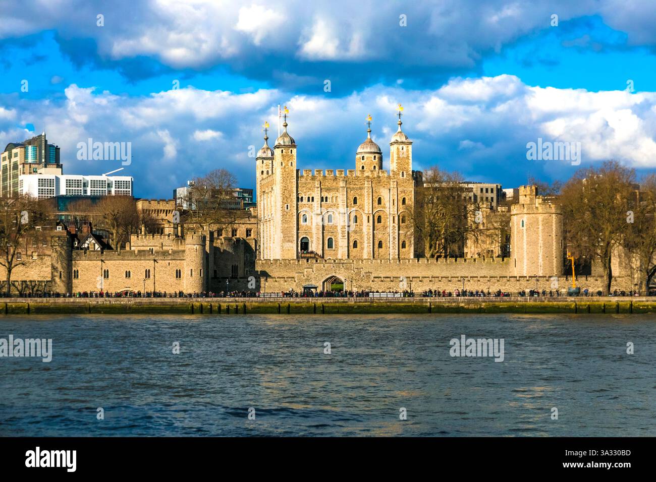 Malerische Nahaufnahme des berühmten Tower of London mit seinem berühmten White Tower, von der anderen Seite der Themse aus gesehen an einem sonnigen Tag mit blauem Himmel. Stockfoto