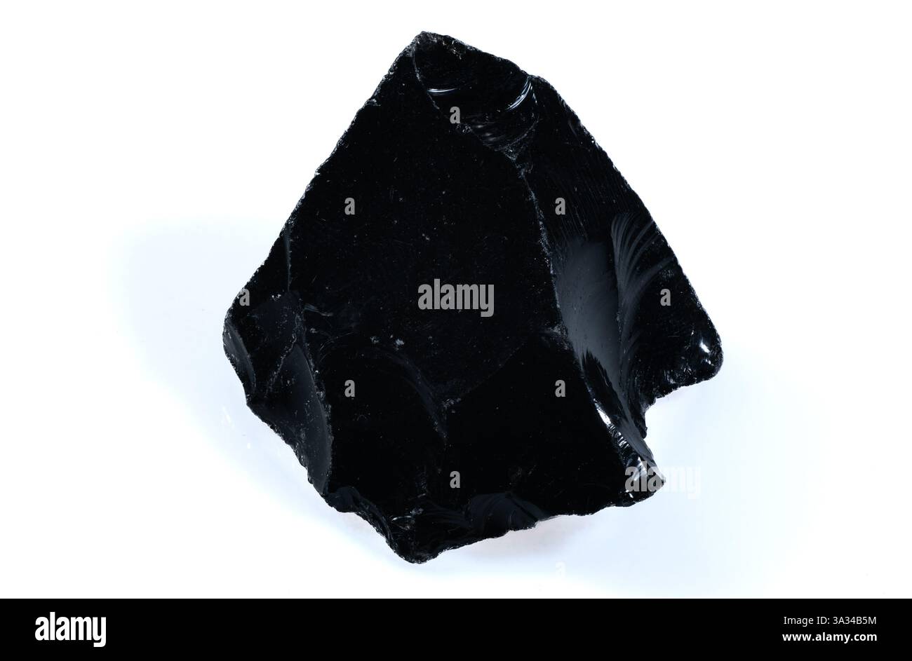 Glänzendes schwarzes natürliches Obsidian-Steinfragment mit scharfen Kanten auf weißem Hintergrund. Stockfoto