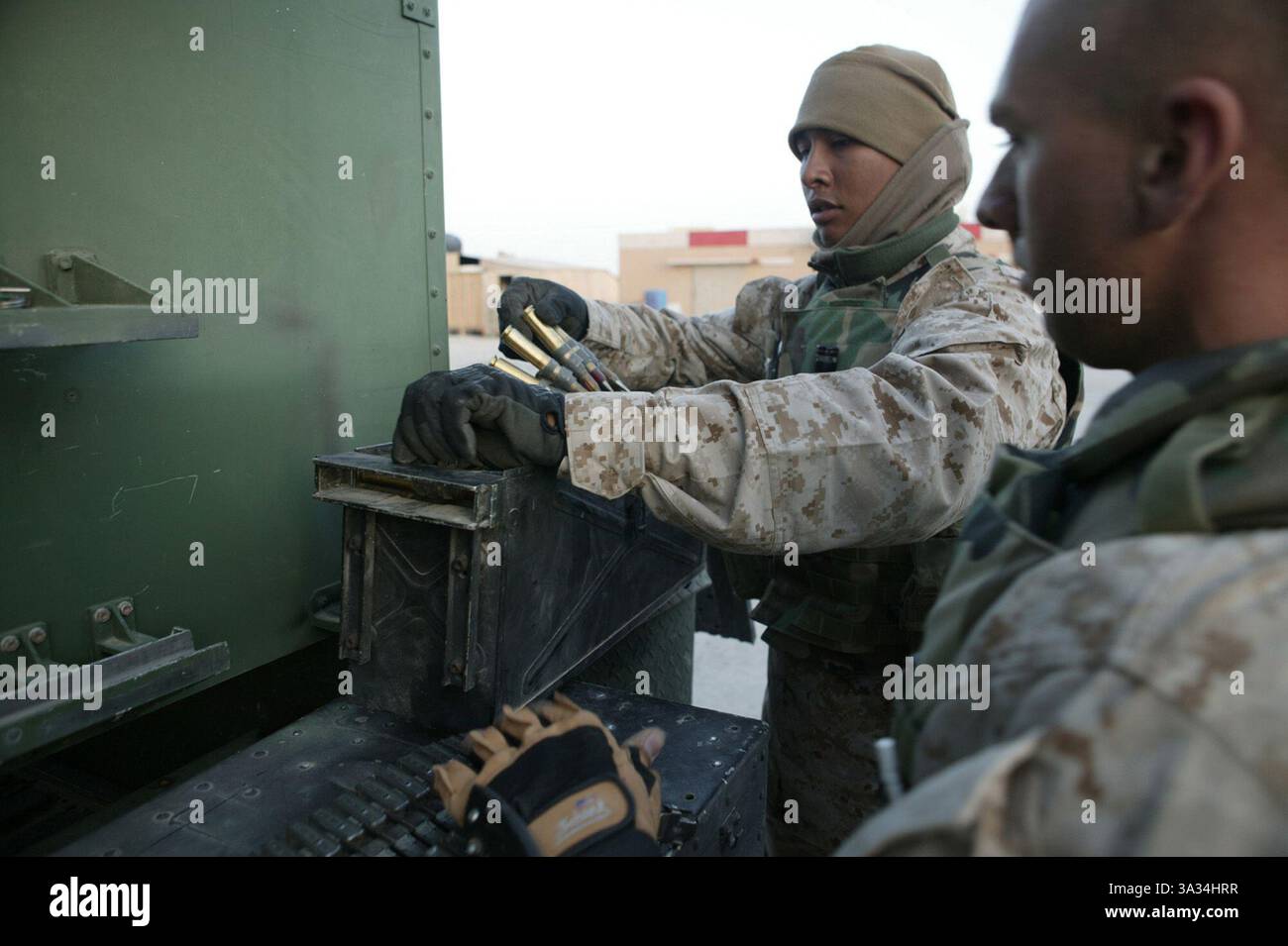 März 2004; Al Asad, Irak; JUAN J. ROSALES (links), ein 20-jähriger Einwohner von Dallas, und Sgt. JERAMY SZMANSKI, ein 24-jähriger Fort Smith, Ark., beide aus der Alpha Company, 3. Low Altitude Air Defense Battalion, entfernen die Munition aus einem Maschinengewehr des Kalibers .50 nach einer nächtlichen Beobachtungspatrouille am 25. März. Das Maschinengewehr des Kalibers .50 wird verwendet, um ein Ziel zu „markieren“, bevor die Flugabwehrrakete vom Avenger-Fahrzeug abgefeuert wird. Marines der 3. LAAD und der Lima Company, 3. Bataillon, 24. Marine Regiment, sind dem 3. Marine Aircraft Wing als Sicherheitsbataillon und angegliedert Stockfoto