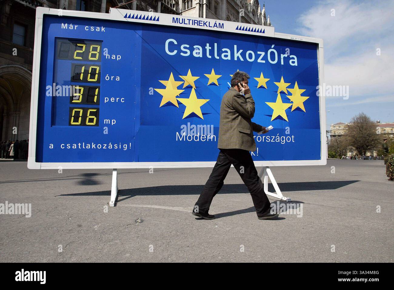 2. April 2004; Budapest, UNGARN; Eine Uhr vor dem nationalparlament zählt die Tage, Stunden, Minuten und Sekunden herunter, die noch bis zum Beitritt Ungarns und neun anderer, überwiegend ehemaliger sowjetischer Blockstaaten der Europäischen Union verbleiben. Auf dem Schild steht: "Countdown Clock, Building a modern Hungary." Ungarn feiern am 1. Mai 2004 den bevorstehenden Attentat ihres Landes an die Europäische Union. Am 1. Mai werden zehn neue Länder der EU beitreten, was insgesamt 25, 19 mehr macht als die sechs Länder vor 50 Jahren. Die EU wird mit 74 Mio. n der größte Handelsblock der Welt sein Stockfoto