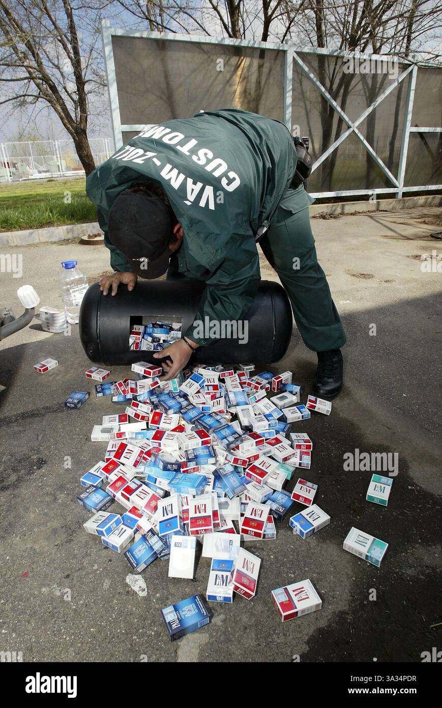 9. April 2004; Artand, UNGARN; Bild: Ein ungarischer Zollbeamter entdeckt geschmuggelte Zigaretten in einem ausgehöhlten Tank eines Autos. Die neuen Länder, die der EU beitreten, werden immer noch ein Privileg verpassen, das der Großteil Westeuropas genießt - ohne Grenzen zu leben. Die Grenzkontrollen zwischen den derzeitigen 15 EU-staaten und den zehn, vor allem osteuropäischen Ländern, die der EU am 1. Mai beitreten, werden mindestens bis 2007 bestehen bleiben. Stockfoto