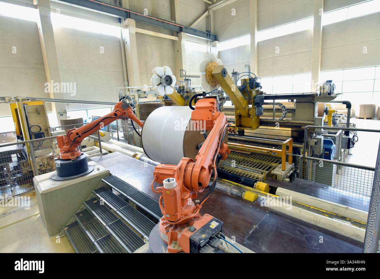 Automatisierte Produktion in einer Papierfabrik – Roboter mit Papierrolle in der industriellen Produktion Stockfoto