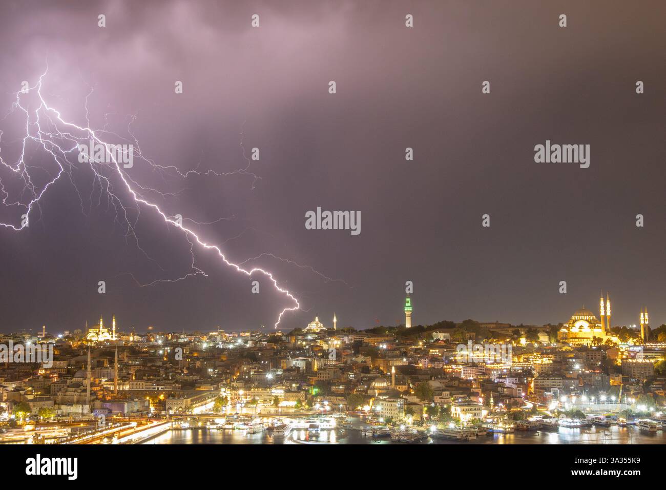 Eine eindrucksvolle Szene mit Blitzen über der nächtlichen Skyline von Istanbul, die historische Wahrzeichen im pulsierenden Glanz der Stadt hervorhebt. Stockfoto
