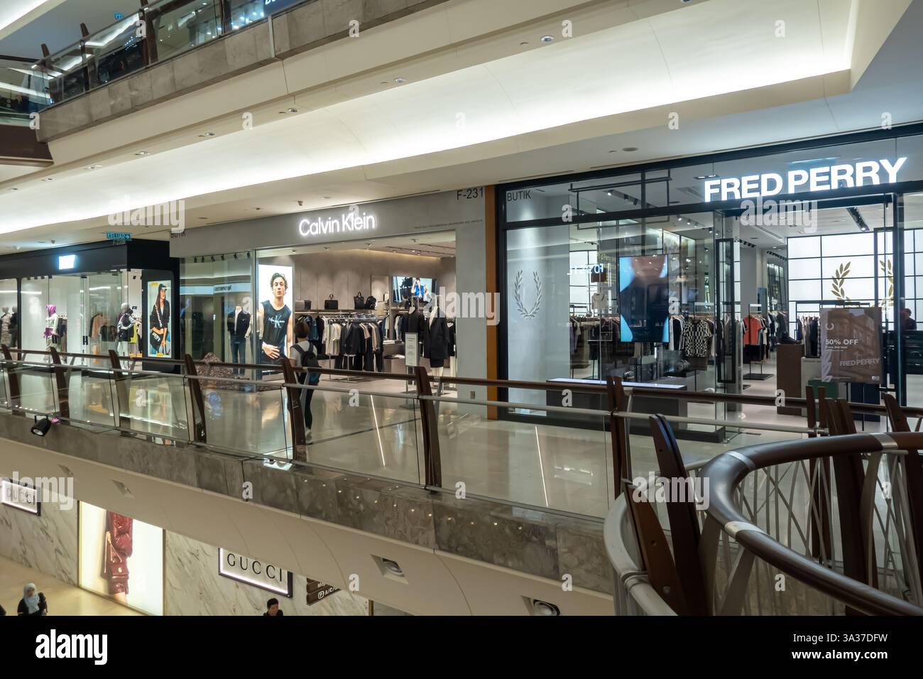 Das Innere von Suria KLCC, Einkaufszentrum, Ladenfronten von mehreren bekannten Marken, darunter Calvin Klein und Fred Perry, Kuala Lumpur, Malaysia Stockfoto