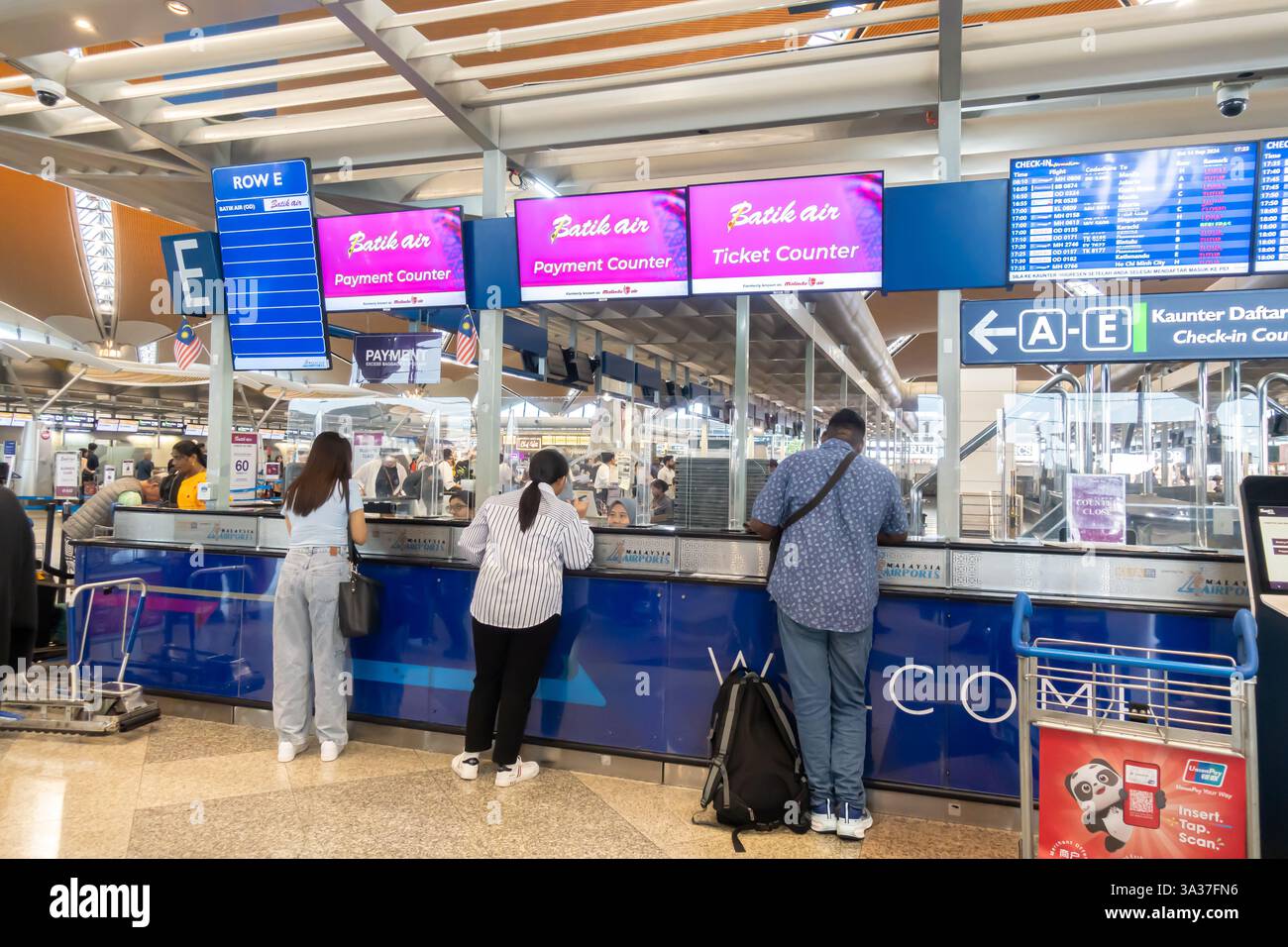 Batik Air Ticketschalter, Check-in-Bereich am internationalen Flughafen Kuala Lumpur (KLIA). Personen werden an den Zählern gesehen, und Bildschirme zeigen Informationen an Stockfoto