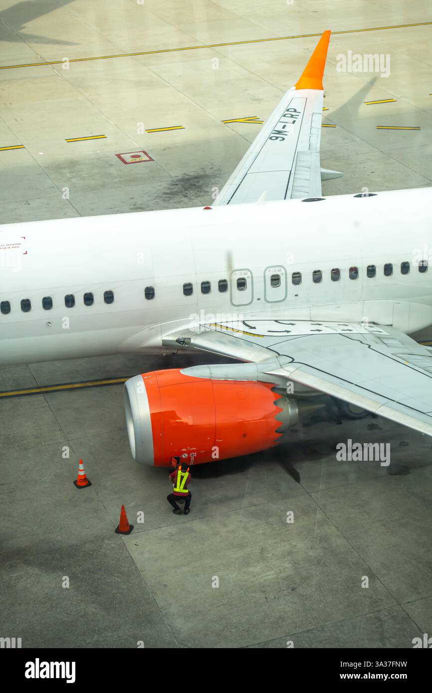 Flughafen Kuala Lumpur, malaysischer Asphalt, Boeing 737-8EH.Schmalraumflugzeuge für kurz- bis Mittelstreckenflüge. Mitarbeiter prüfen den Motor Stockfoto