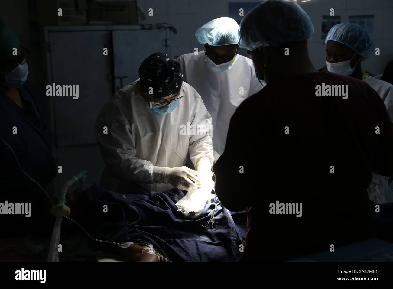 Banjul, Gambia. März 2025. Cai Guiyang, der Leiter der 22. Charge des chinesischen medizinischen Teams, bereitet sich am 12. März 2025 auf eine Operation an einem Patienten in einem Operationssaal des Edward Francis Small Teaching Hospital in Banjul, der Hauptstadt von Gambia, vor. ZU GEHEN MIT 'Feature: Chinesisches medizinisches Team bringt Gesundheit und Wärme zu Gambians' Credit: SI Yuan/Xinhua/Alamy Live News Stockfoto