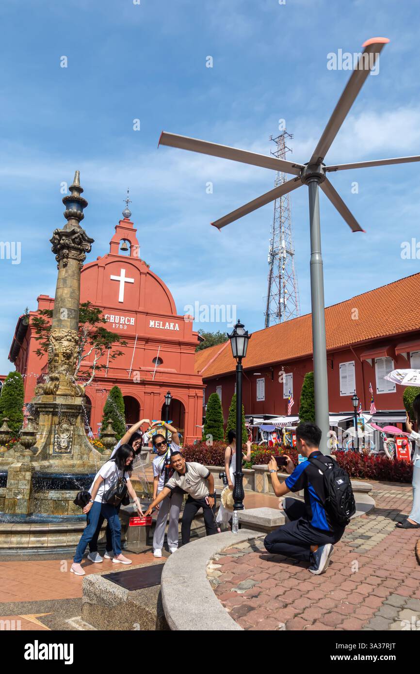 Touristen machen Gruppenfotos am Holländischen Platz in Melaka, Malaysia, mit Christ Church, Stadthuys und dem Queen Victoria Fountain Stockfoto
