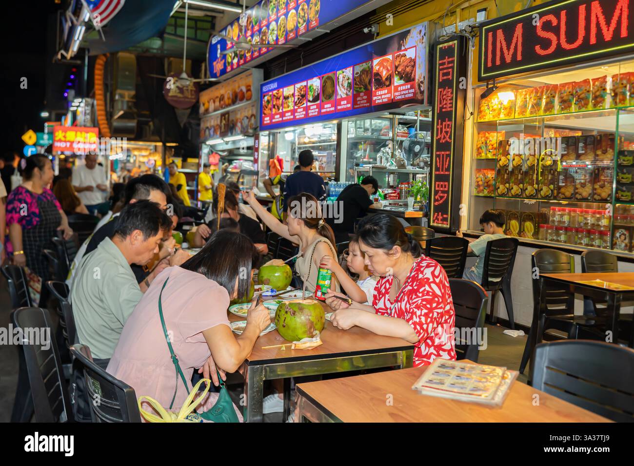 Kuala Lumpur Malaysia, ein beliebtes Hawker Center, lokales Street Food. Familie, Leute an Tischen, Kokosgetränke oder Desserts, die in der Schale serviert werden Stockfoto