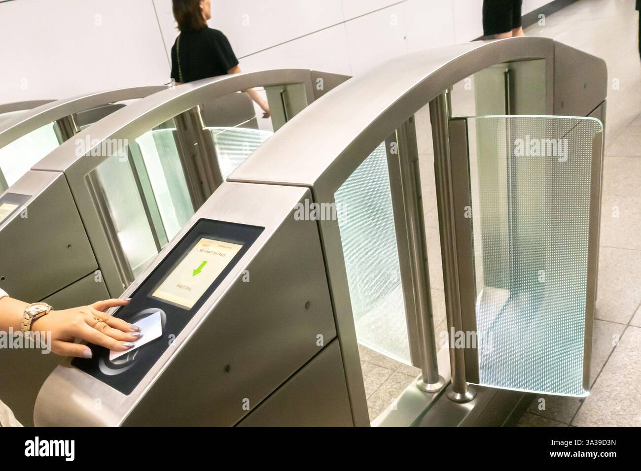 Automatisches Tor, Eingang einer U-Bahn-Station in Kuala Lumpur, Malaysia, mit der Hand einer Person, die eine Karte auf einem Kartenleser klopft. Automatischer Tarif Collec Stockfoto