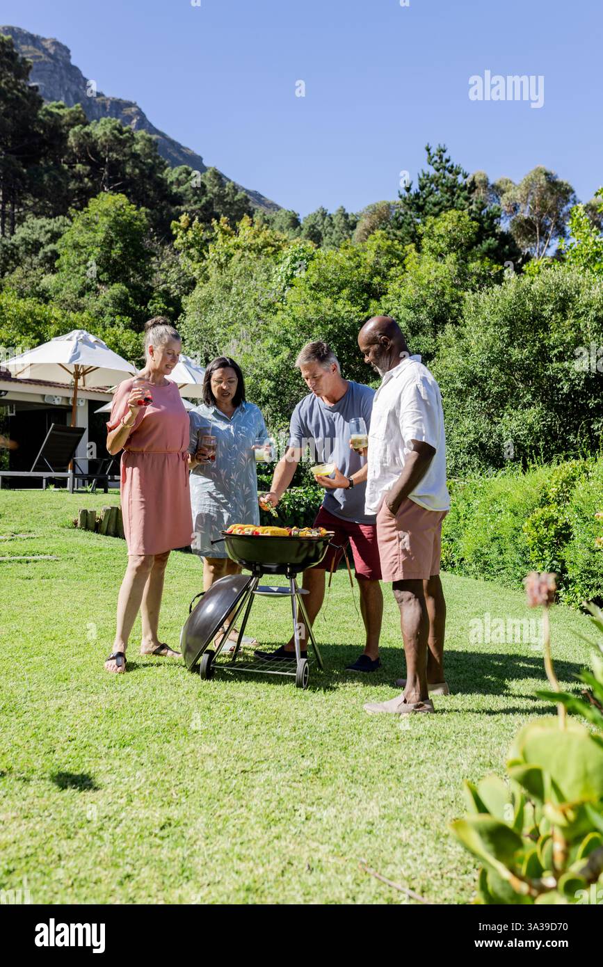 Gruppe von Seniorenfreunden, die im Freien grillen, Essen teilen und lachen im Garten, Kopierraum Stockfoto