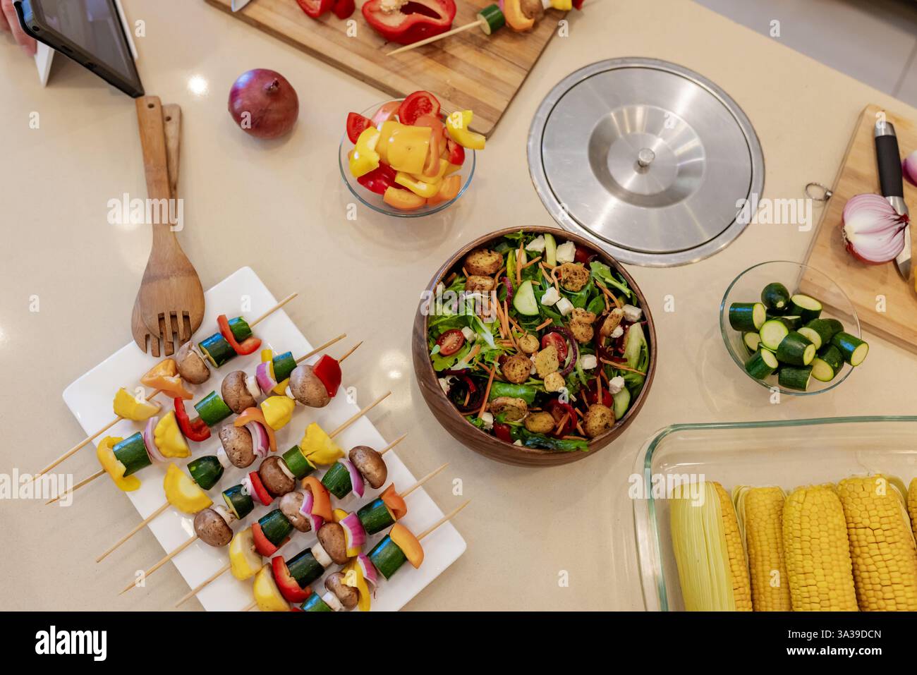 Bunte Gemüsespieße und frischer Salat auf der Küchentheke für gesunde Mahlzeiten Stockfoto
