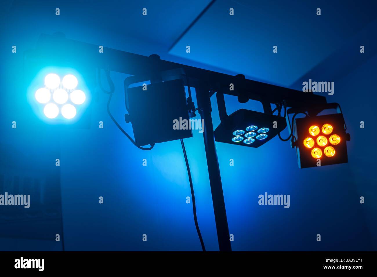 Farbig abgestimmte LED-Spots auf einem Fachwerk vor dunkelblauem Hintergrund in einem Club, einer Disco, einer Party, einem Musikevent oder einer Theaterbühne, Kopierraum, ausgewählt f Stockfoto
