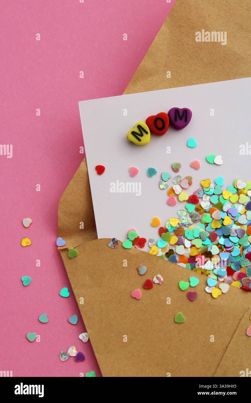 Das Wort MAMA auf einer Karte voller bunter Herzen, die aus einem Umschlag kommen - vertikales Format Stockfoto