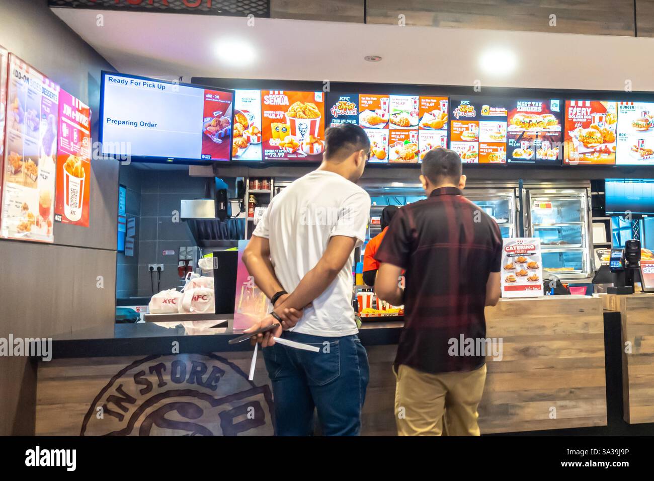 Männer bestellen Essen im KFC (Kentucky Fried Chicken) Restaurant, Kuala Lumpur, Malaysia Stockfoto