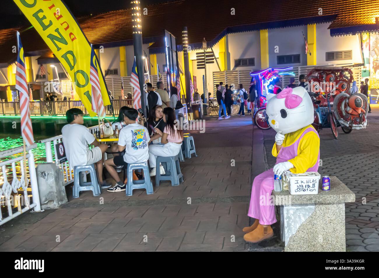 Tierkatze-Imitator, Straßenunterhalter mit einer Tippbox, Malacca Malaysia, Nacht Stockfoto